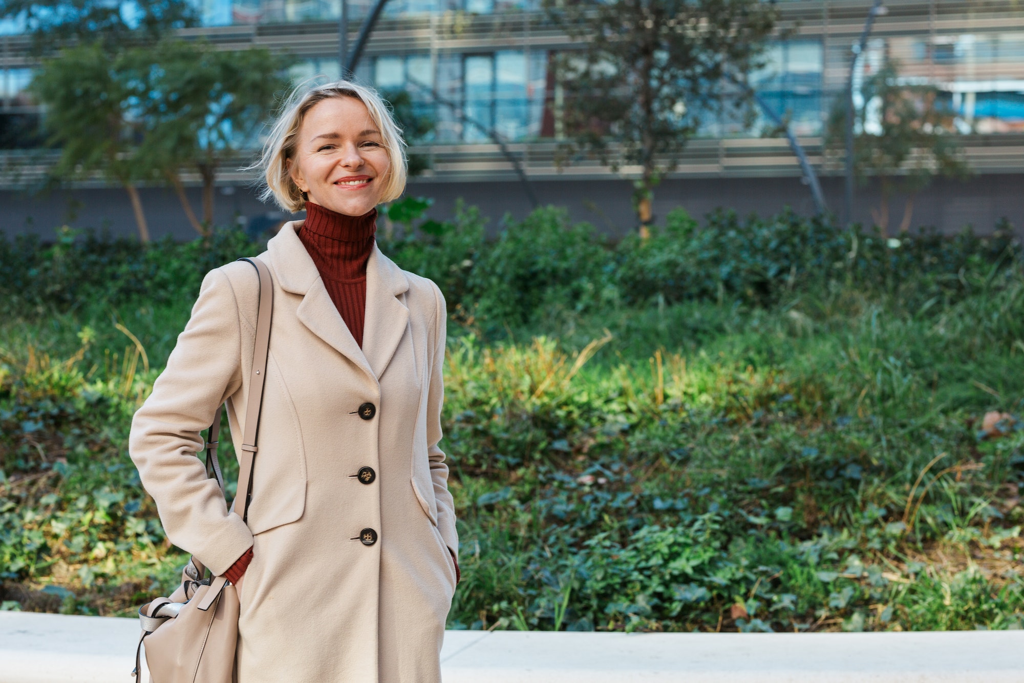 stylish-business-woman-smiling-while-standing-outdoors-in-the-financial-district